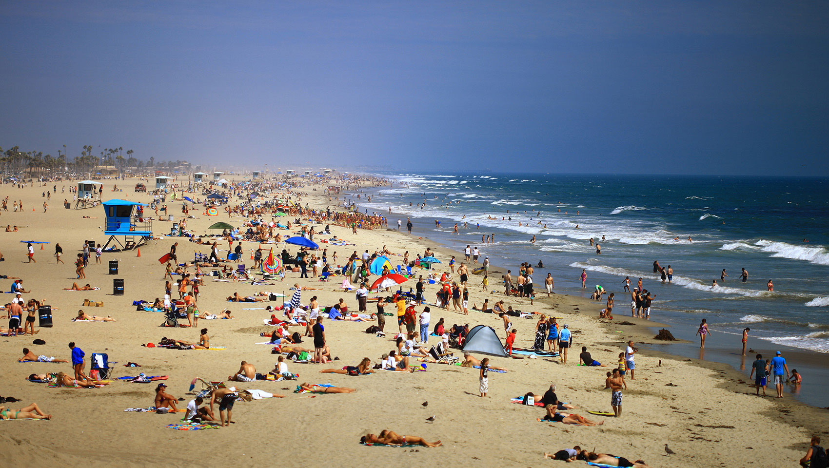 huntington beach with sunbathers and surfers