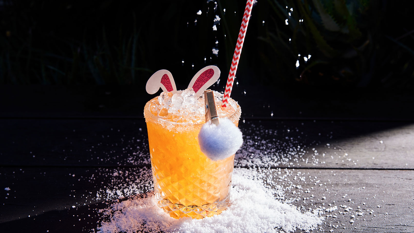 orange cocktail with paper bunny ears and a little puff ball tail