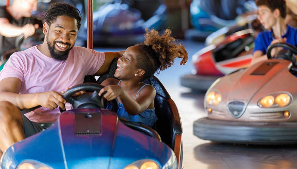 father and daughter on bumper cars