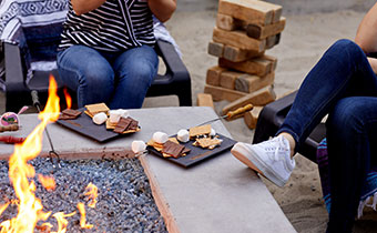 couple making smores outside by a firepit
